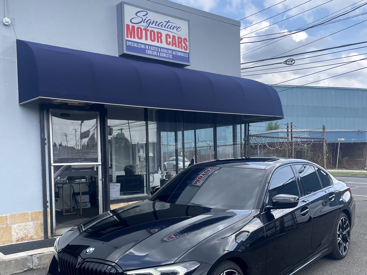The Signature Motor Cars showroom, with a black BMW 3 Series parked out front